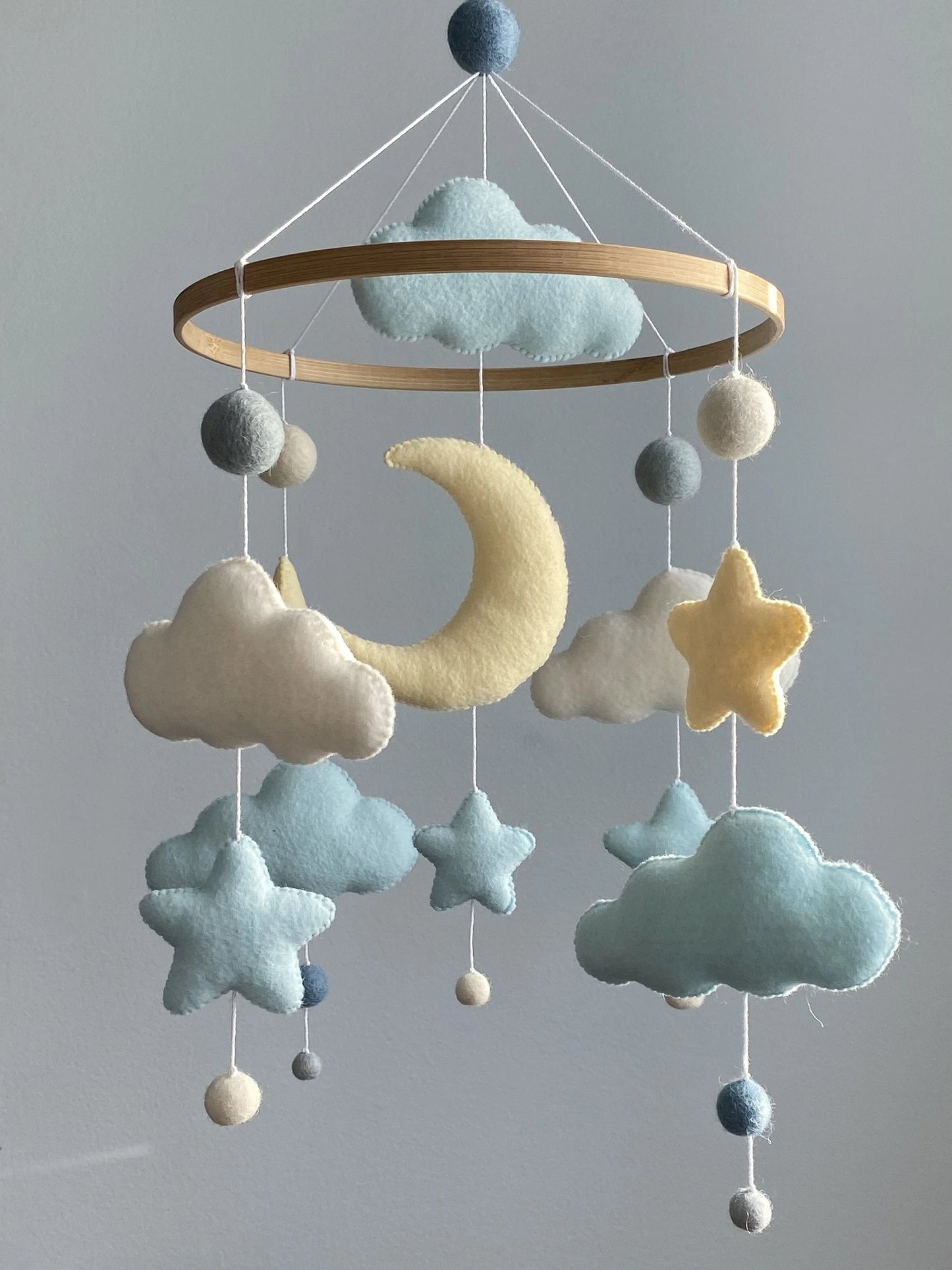 Gender neutral moon and cloud mobile hanging above crib
