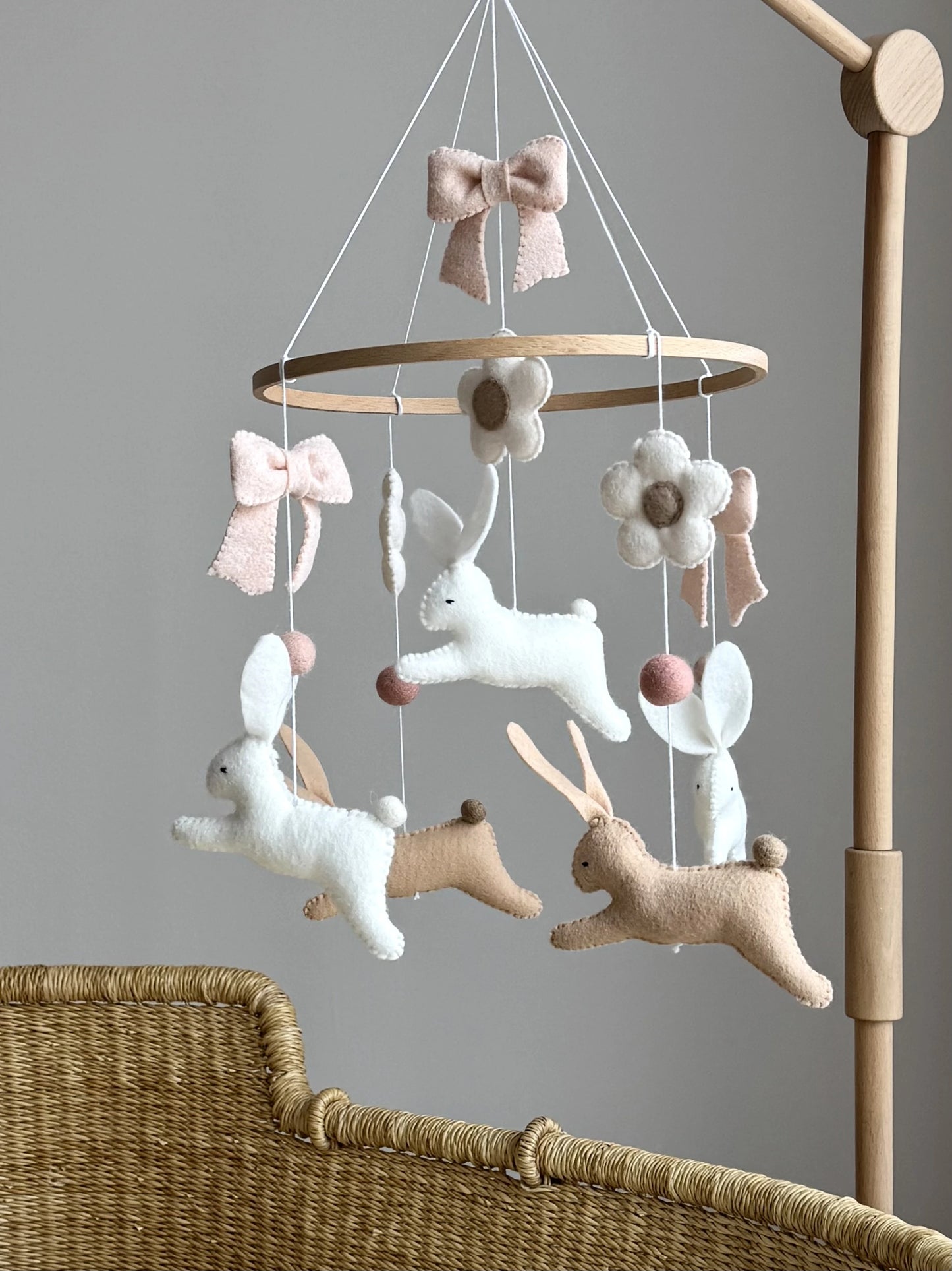 neutral bunny nursery mobile with handmade felt rabbits above crib